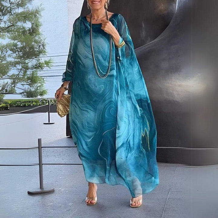 Model posing in teal swirl-pattern flowy kaftan maxi dress