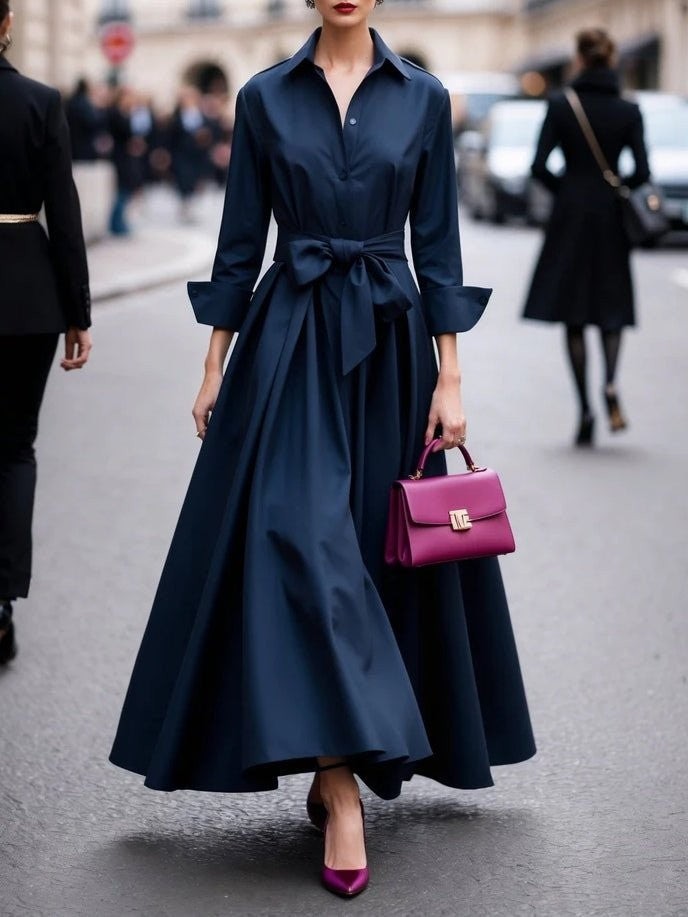 Navy blue belted shirt dress featuring long sleeves and flowing high-low maxi skirt