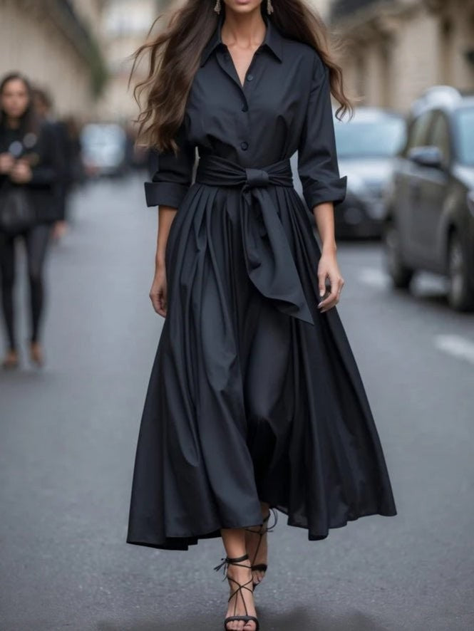 Black collared maxi dress with sash tie waist and dramatic pleated high-low skirt
