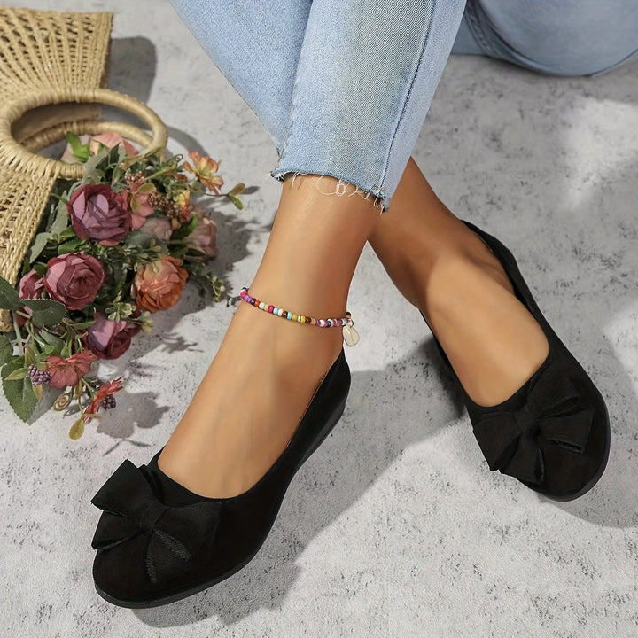 Gray suede low wedge ballet flat with bow detail and heel height label