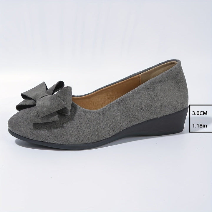 Gray suede bow ballet flats displayed together showing low wedge heel