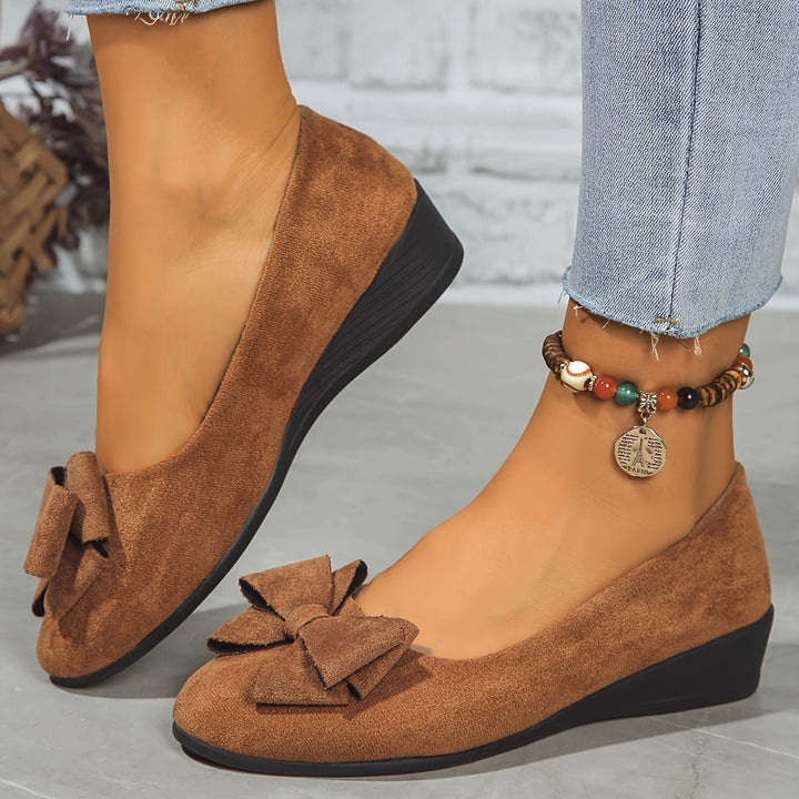 Brown suede bow ballet flats paired with beaded anklet and denim