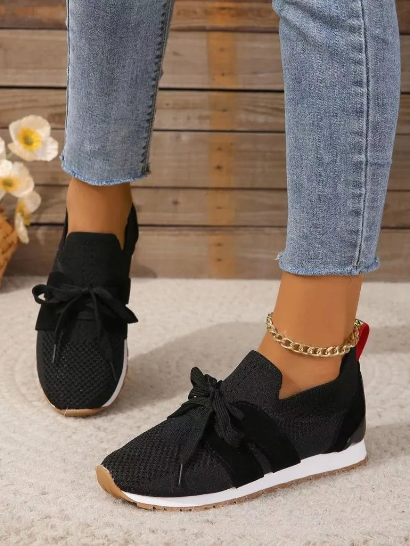 Black mesh slip-on sneakers styled with cropped denim jeans
