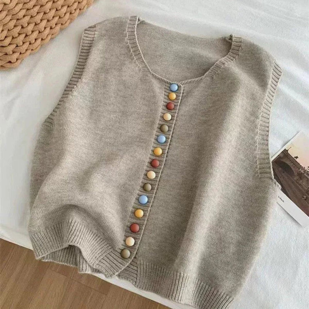 Gray sleeveless knit cardigan with multicolor buttons laid flat
