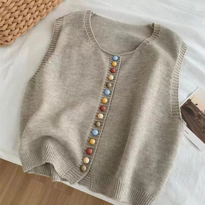 Gray sleeveless knit cardigan with multicolor buttons laid flat