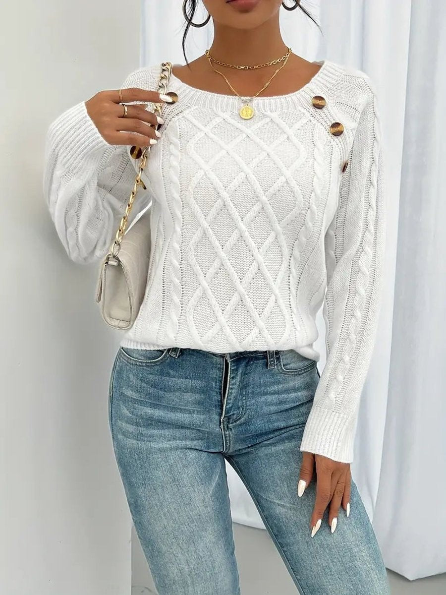 Model wears white cable knit sweater paired with denim jeans