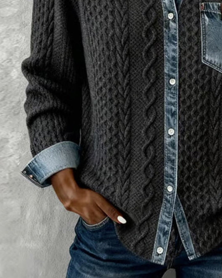Close-up of black cable-knit sweater shirt with denim button placket and pocket
