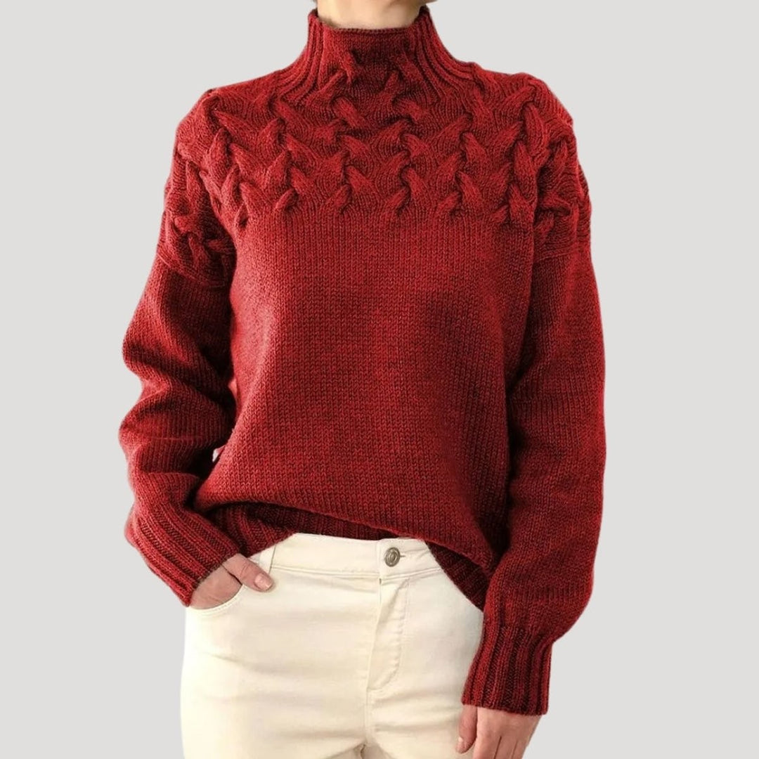 Rust red cable knit turtleneck sweater featuring chunky braided knit yoke