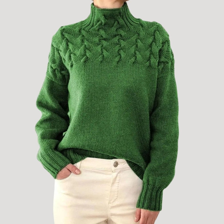 Green cable knit turtleneck sweater featuring textured braided shoulder pattern