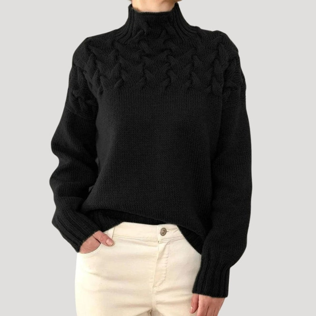 Black cable knit turtleneck sweater featuring braided chunky knit yoke