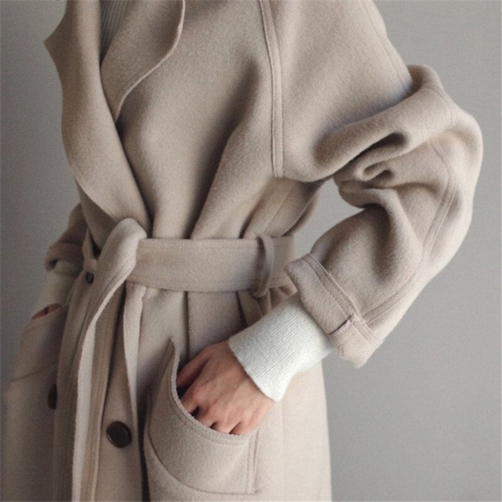 close-up of beige wool coat sleeve and belted waist detail