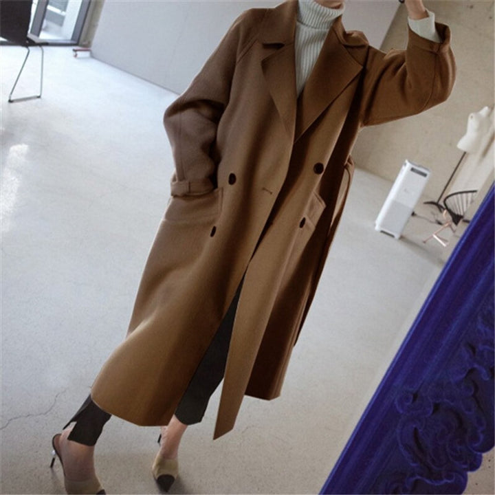 camel long wool coat worn open over black trousers and heels