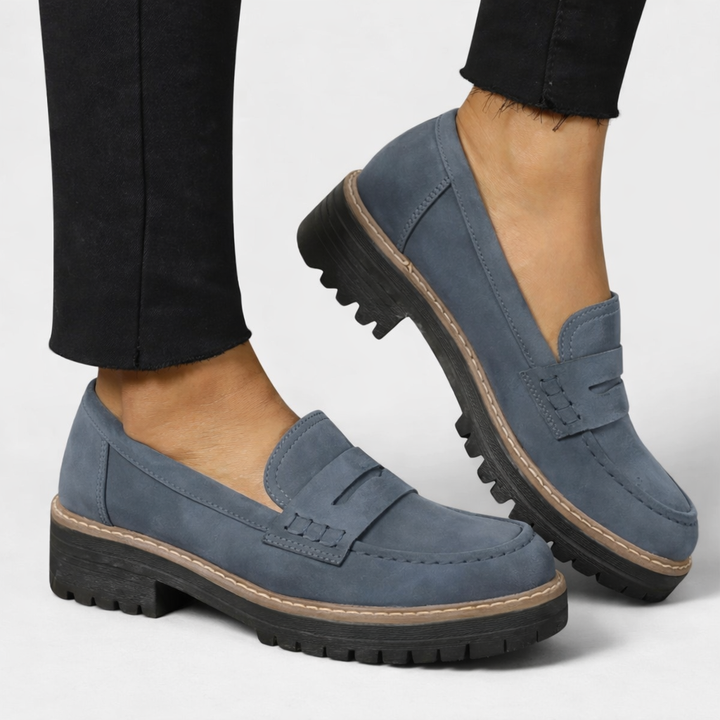 blue-gray suede penny loafers with thick tread sole and tan trim