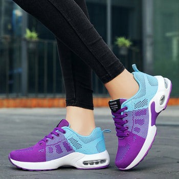 Woman wearing purple and blue mesh sneakers walking on city sidewalk