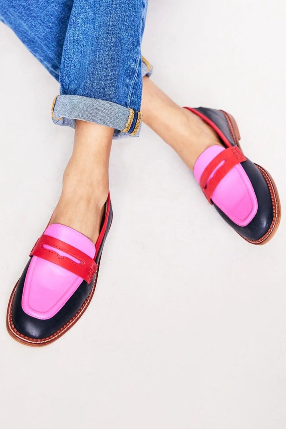 Color-block leather penny loafers in navy, pink, and red with cuffed jeans