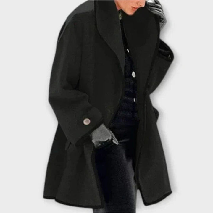 Black oversized swing coat with contrast trim and dramatic shawl collar