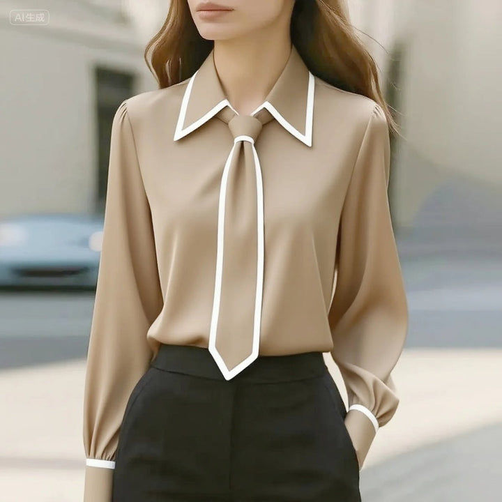 Beige tie-neck blouse featuring white piping and pointed collar