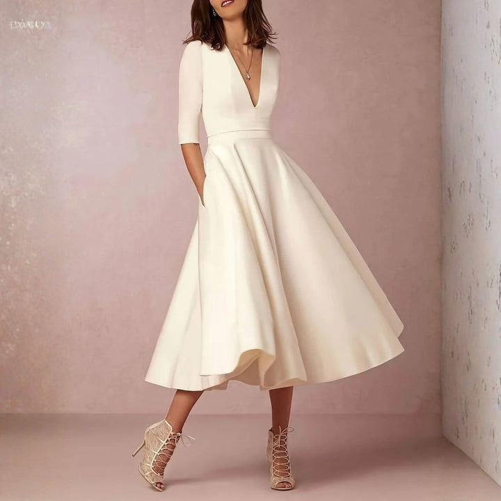 Deep V-neck ivory midi dress paired with lace-up heeled sandals
