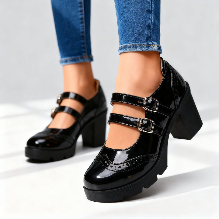 Black patent leather Mary Jane heels with silver buckle straps and platform sole