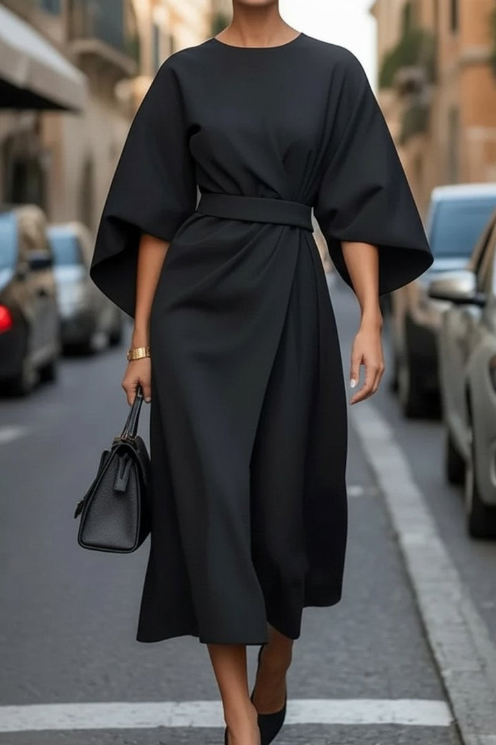 Black belted midi dress featuring cape sleeves and draped front skirt