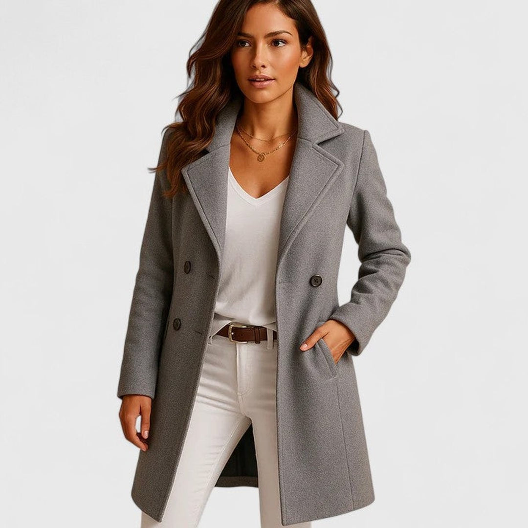 Gray notch-lapel wool coat with double-breasted buttons, worn over white top