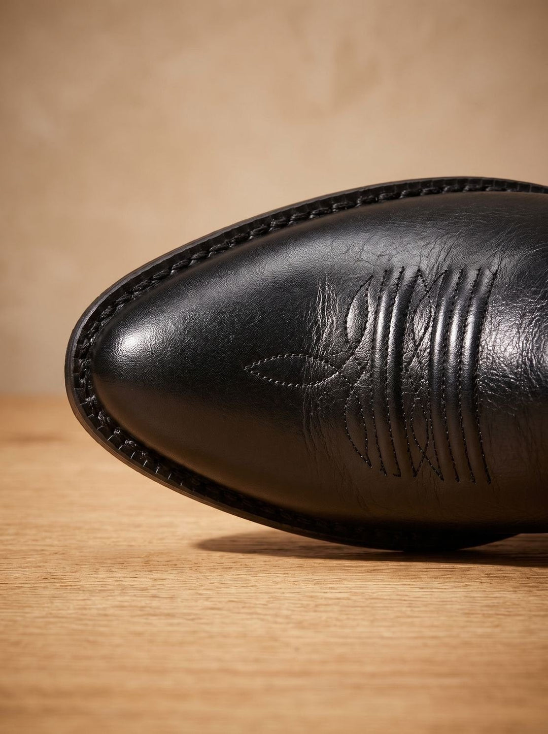 Front view of black cowboy boot highlighting pull tabs and embroidered shaft