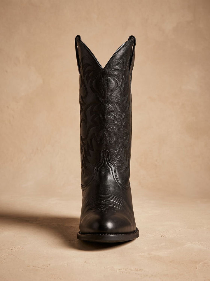 Side profile of brown leather cowboy boot with pointed toe and low heel