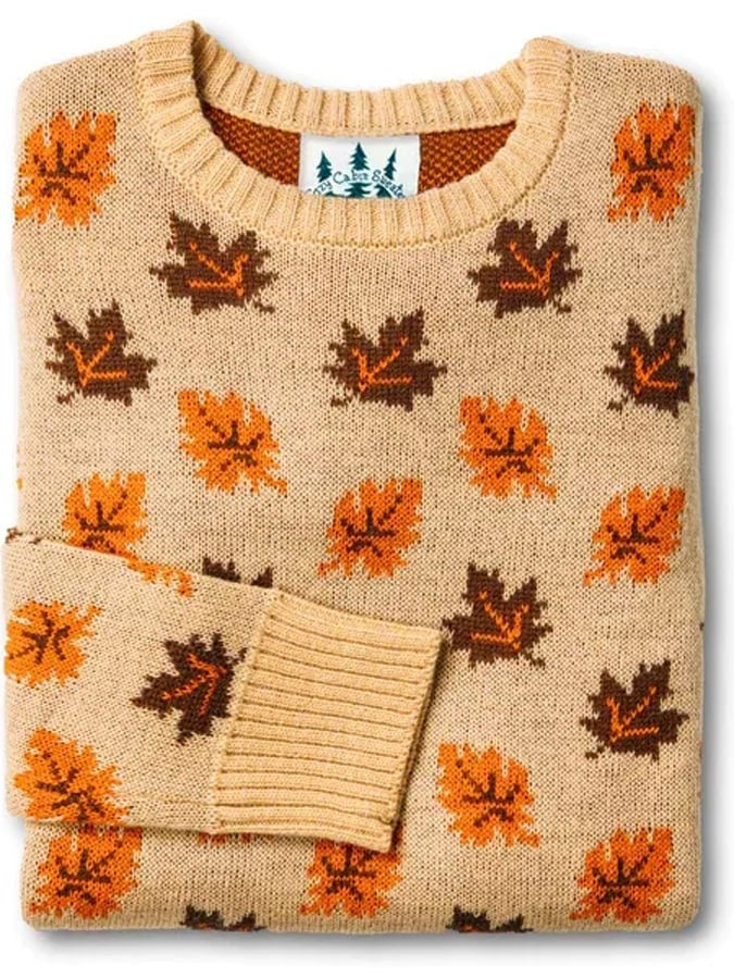 Tan crew-neck sweater covered in orange and brown maple leaf print