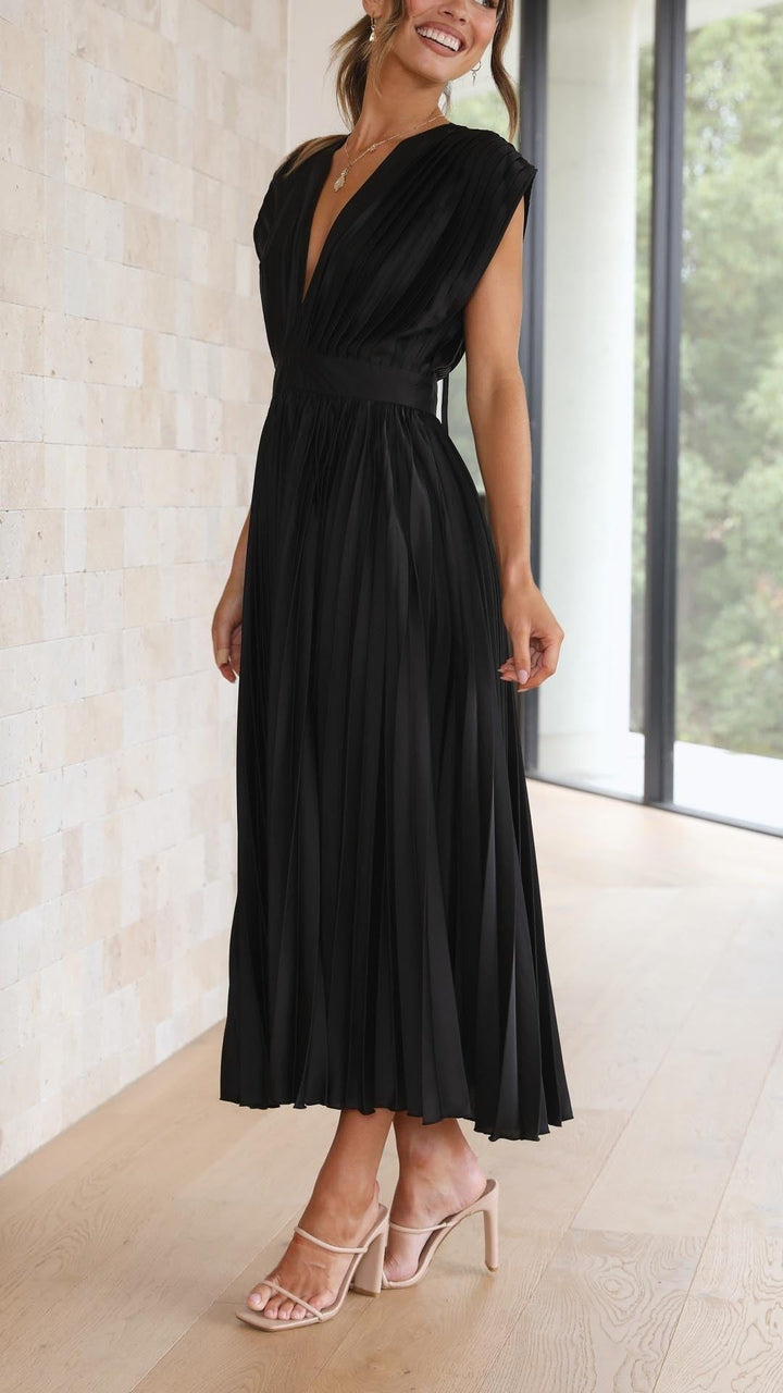 Back view of black pleated dress with open back and tie strap