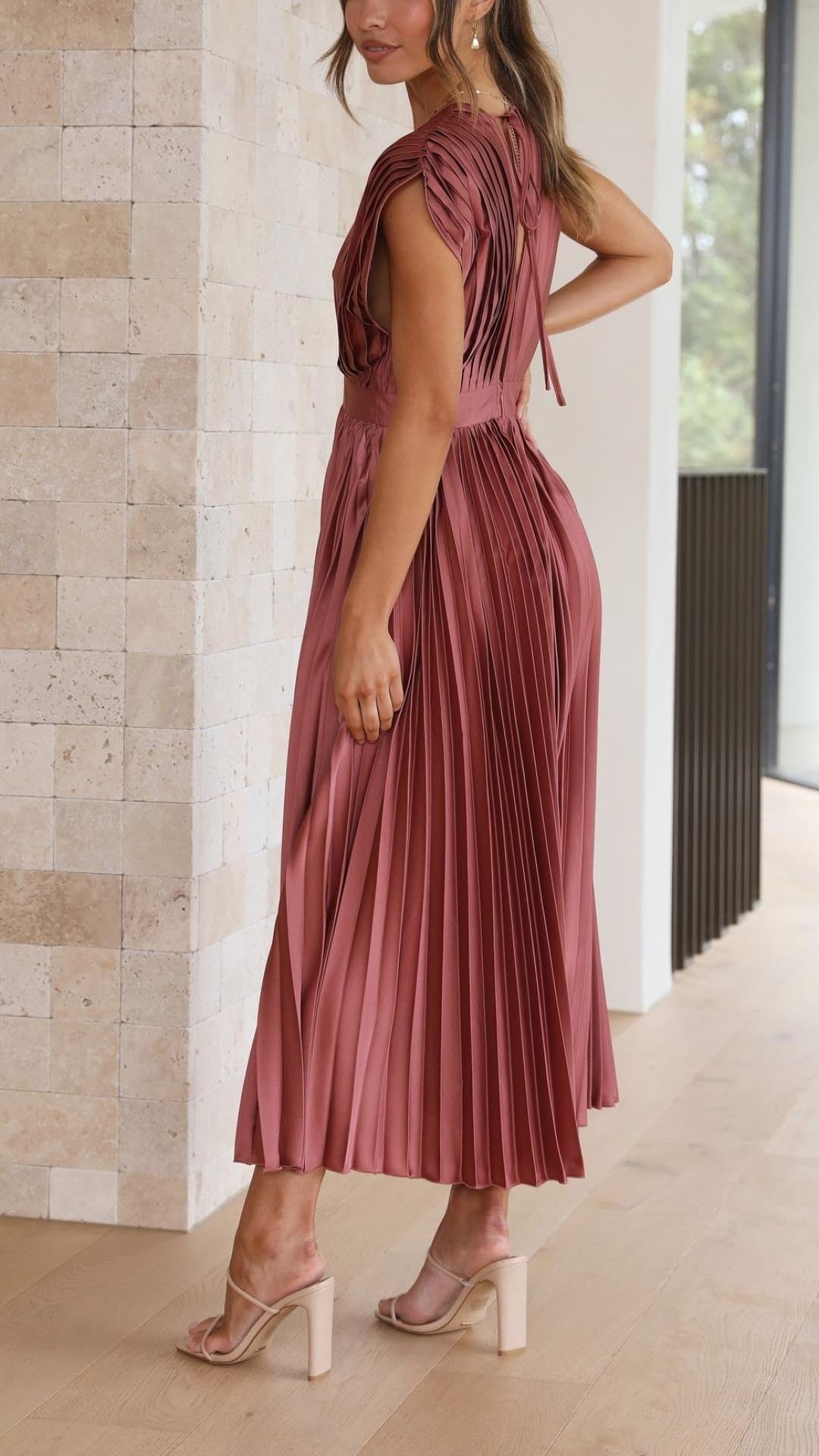 Back view of rust pleated maxi dress showing cap sleeve detail