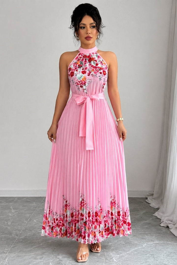Pleated pink floral halter dress featuring belted waist and flowy skirt