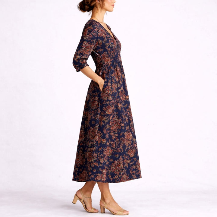 Navy floral print midi dress with V-neck, shown in side profile walking pose