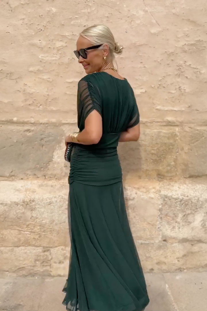 Back view of emerald ruched maxi dress showing sheer sleeve detail