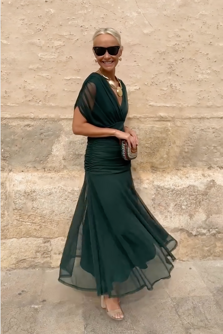 Side profile of green V-neck maxi dress with dramatic mermaid-style skirt