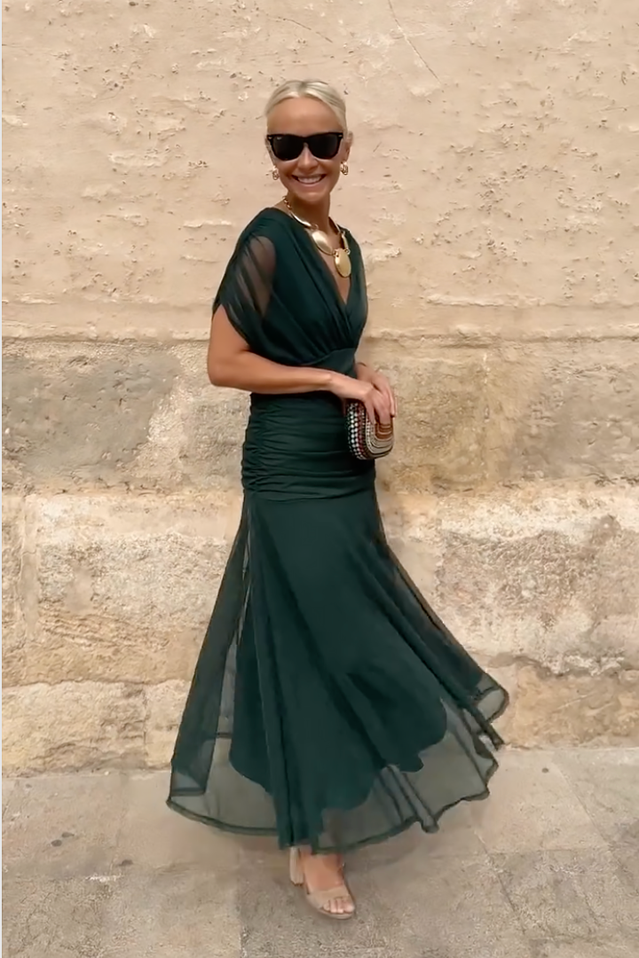Side profile of green V-neck maxi dress with dramatic mermaid-style skirt