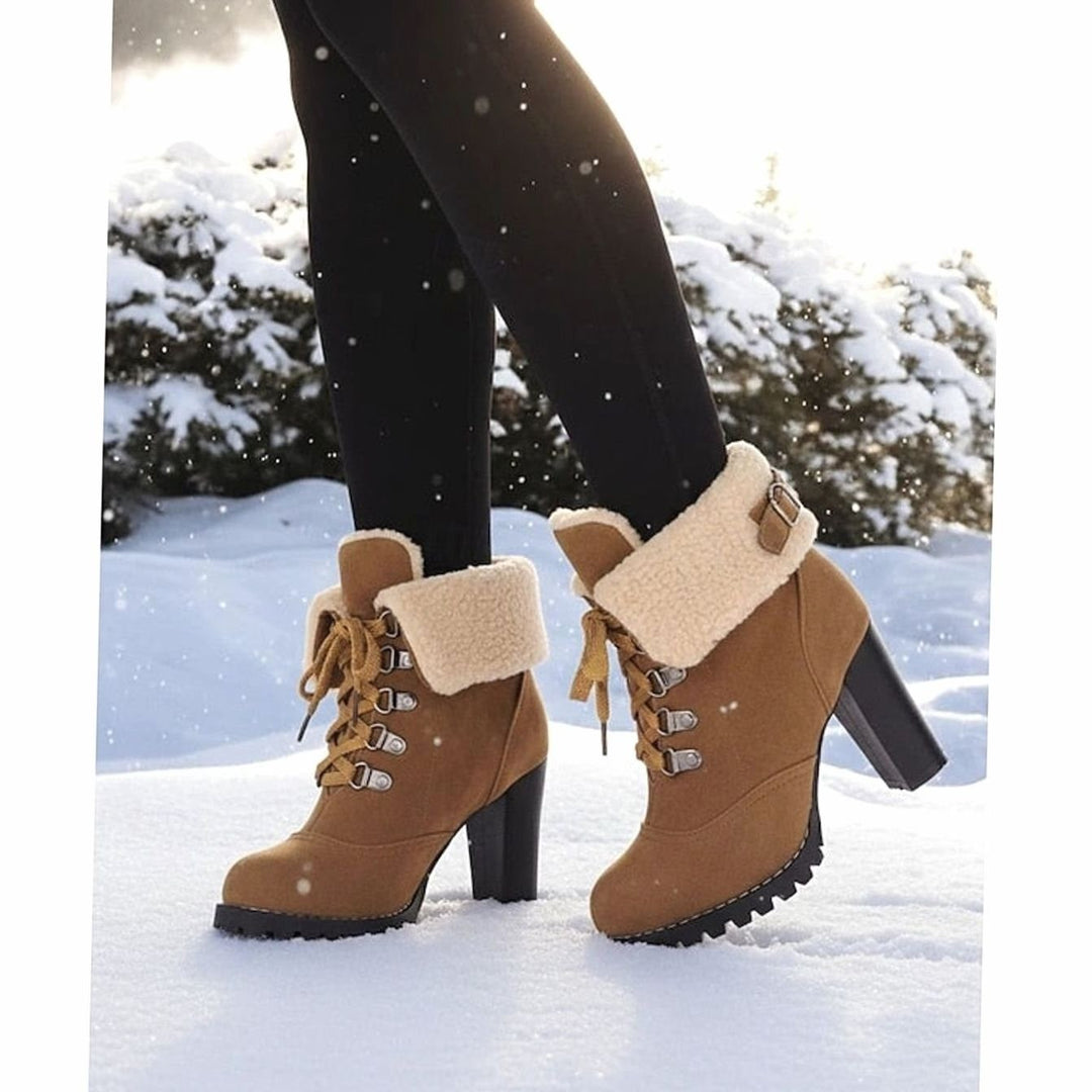 Model wearing camel suede boots with fleece cuff walking through snow