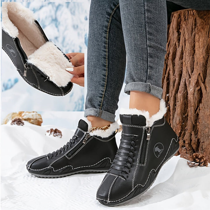 Black faux-fur lined ankle boots with zipper closure and stitched leather design