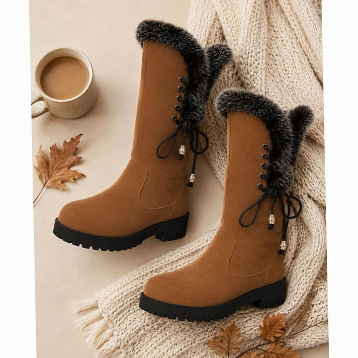 Tan suede fur-trimmed boots styled with knit sweater and coffee cup