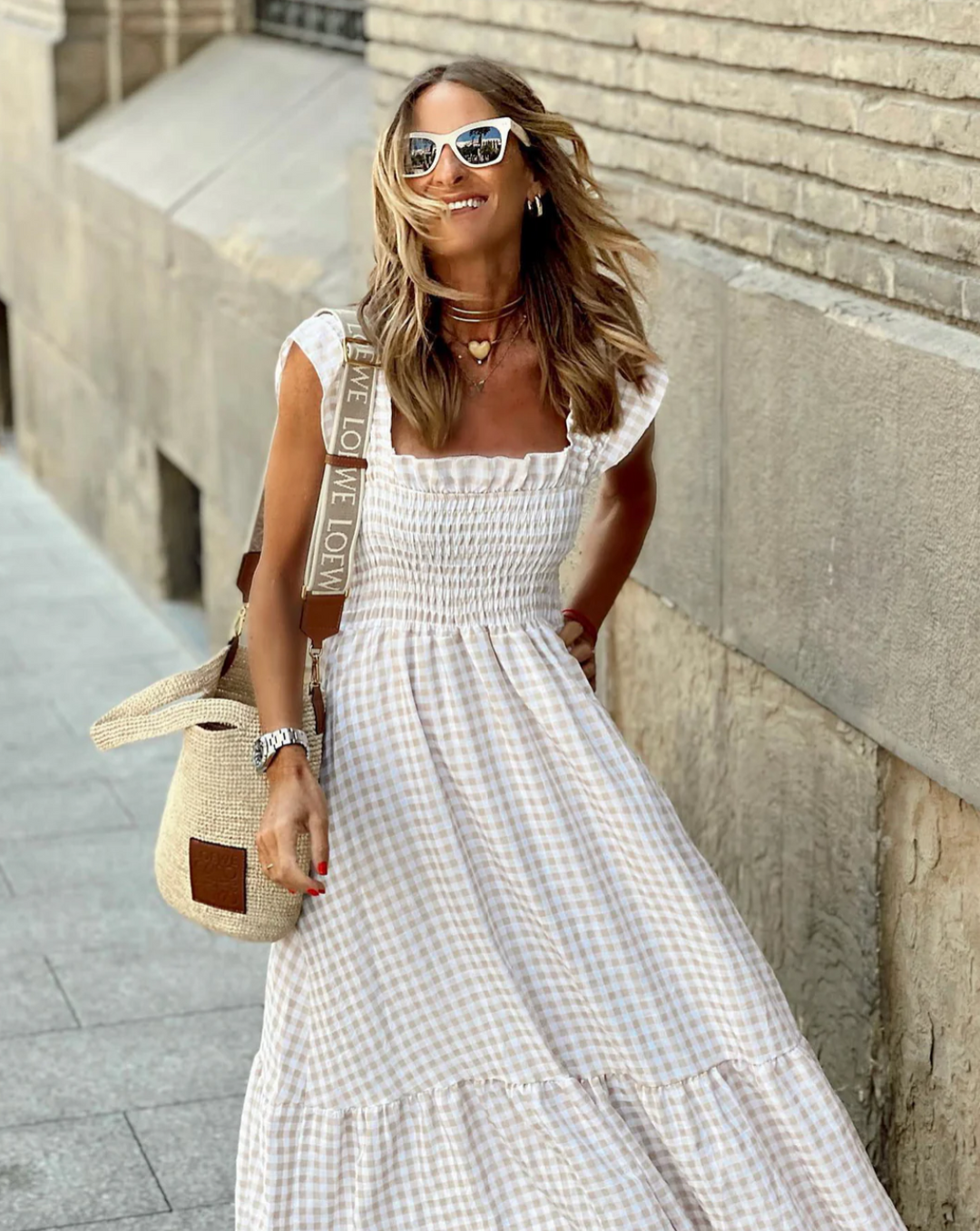 beige gingham maxi dress with smocked bodice paired with a crossbody straw bag