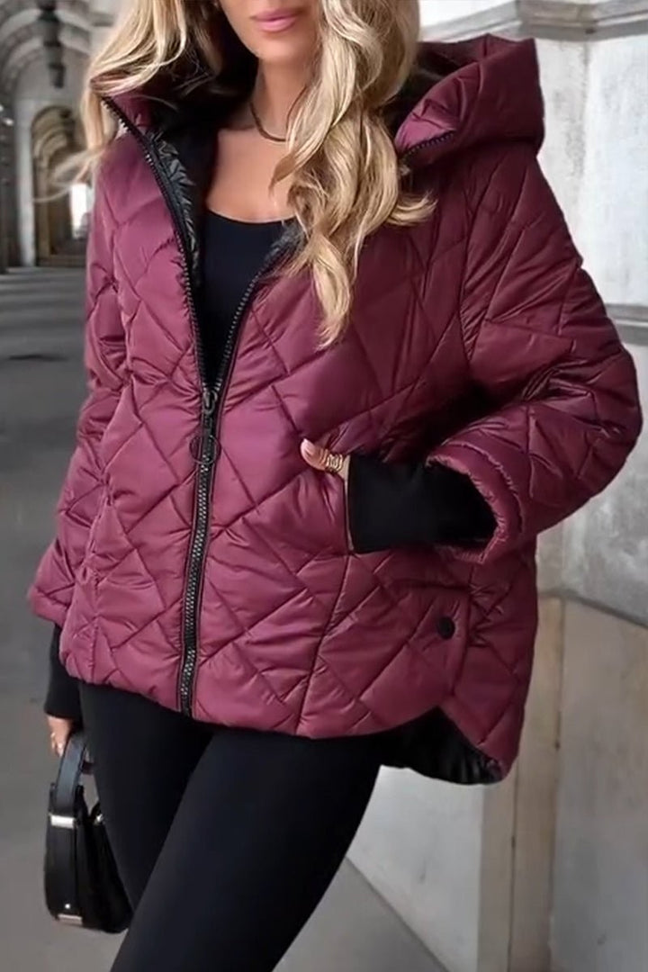 Burgundy hooded puffer jacket paired with black leggings and handbag