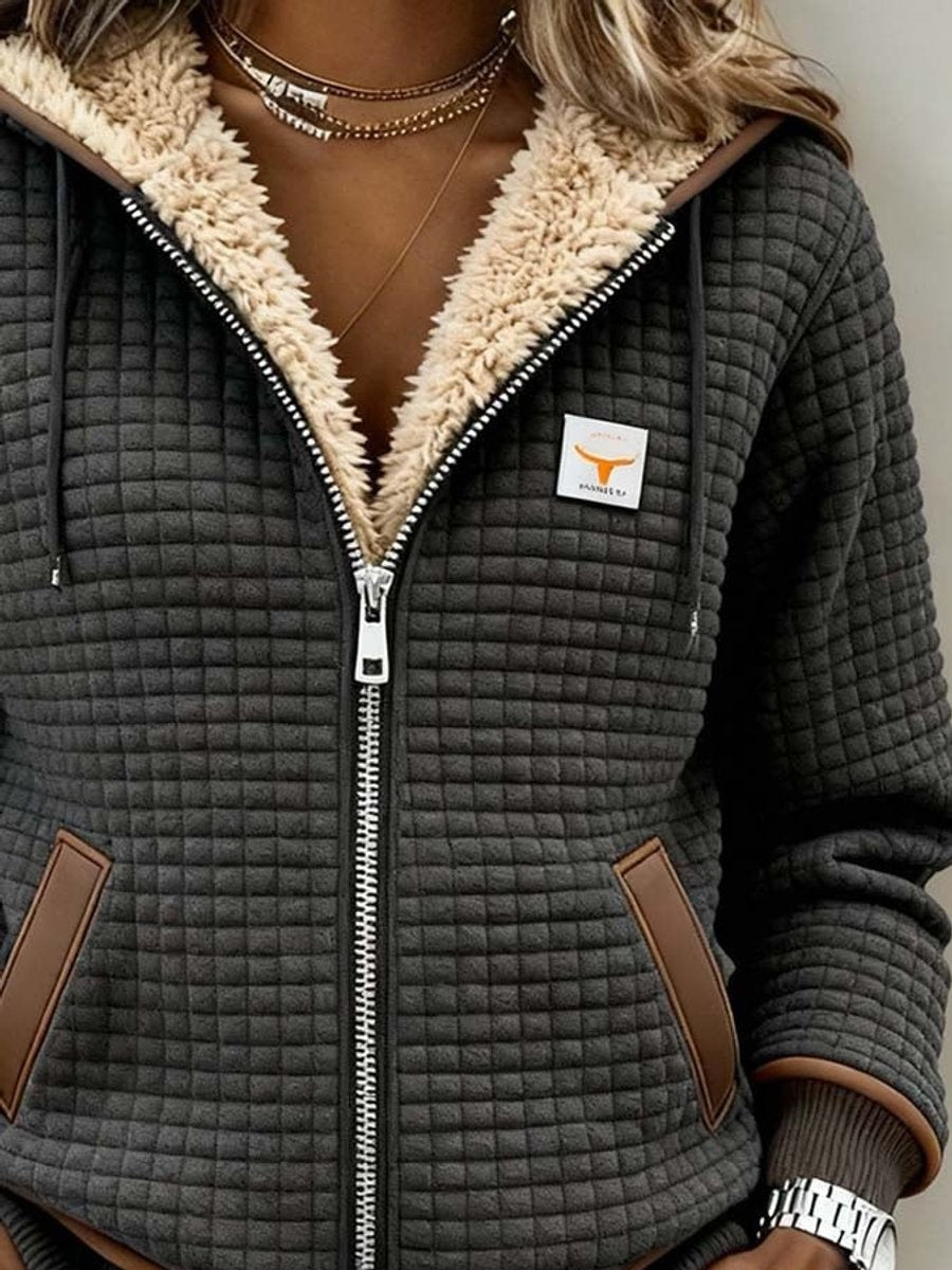 close-up of dark gray quilted jacket with fuzzy cream hood lining and zipper