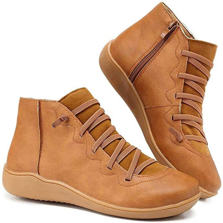 Tan leather ankle boots with crisscross lace detail and side zipper