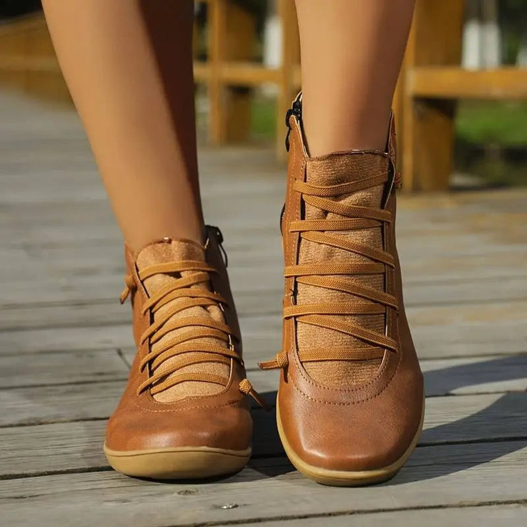 Front view of tan lace-up ankle boots on model's feet outdoors