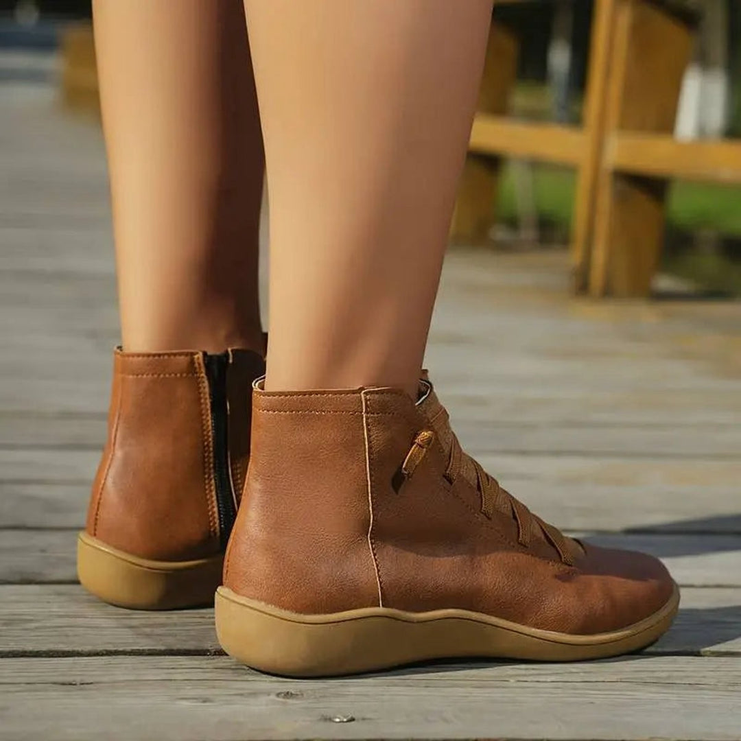 Back view of tan leather ankle boots showing side zip and heel