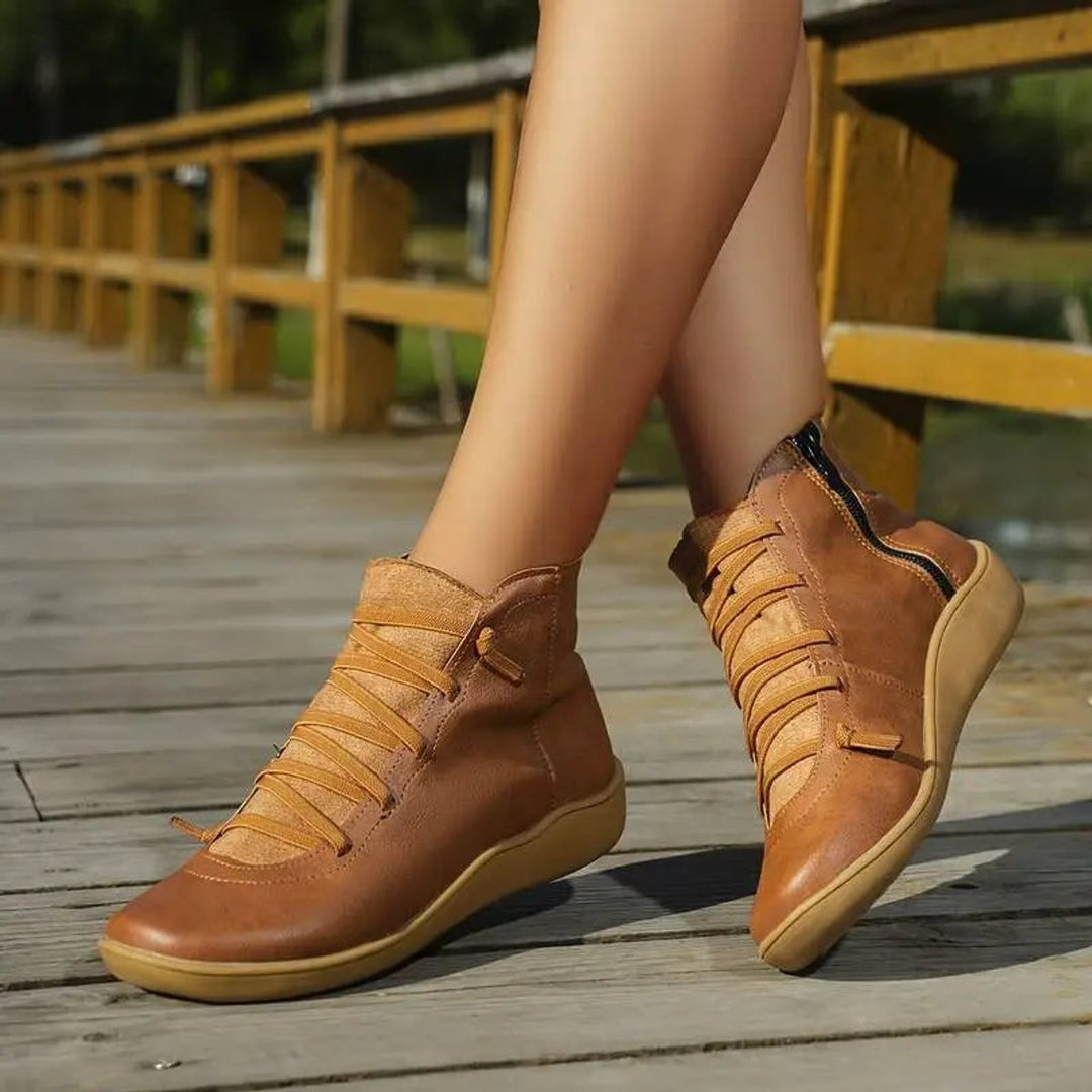 Tan lace-up ankle boots worn with side zipper visible outdoors