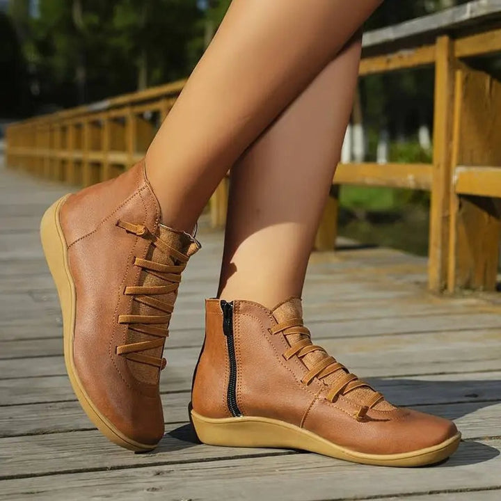 Close-up of tan leather ankle boots with crisscross elastic laces