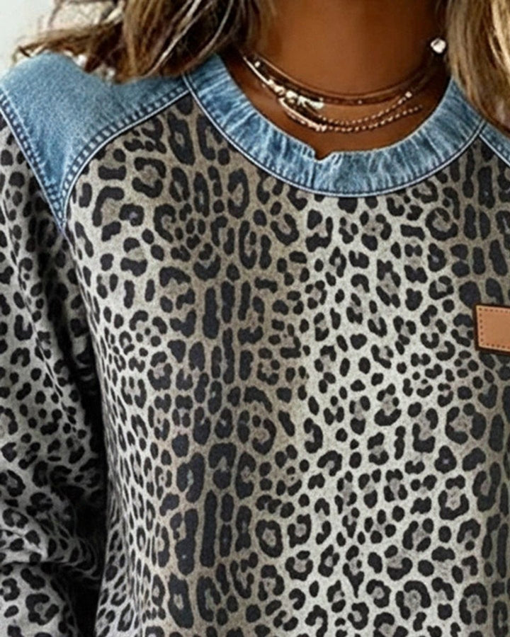 Close-up of gray leopard print top with denim neckline trim and patch