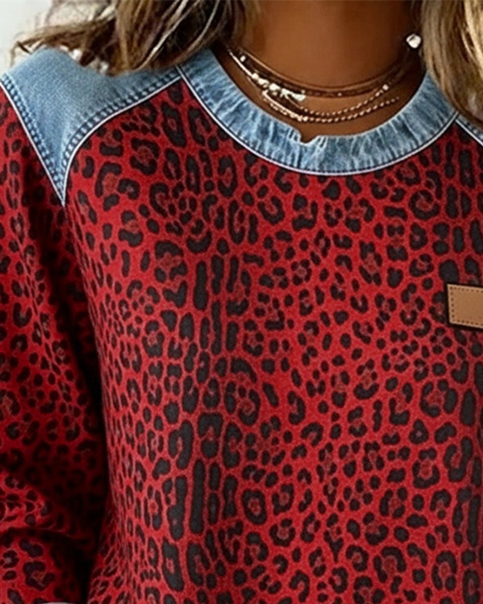 Close-up of red leopard print sweatshirt with denim collar and shoulder trim