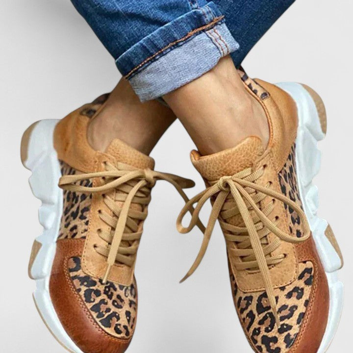 close-up of laced leopard-print sneakers styled with rolled denim jeans