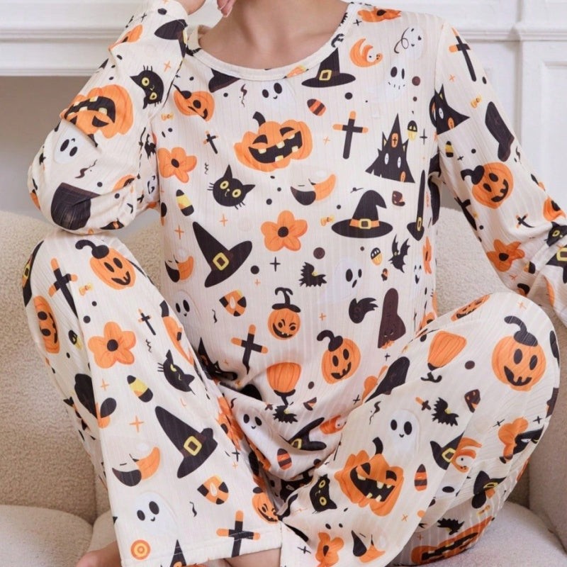 Woman sits wearing long-sleeve pumpkin and ghost print pajama set, close-up view